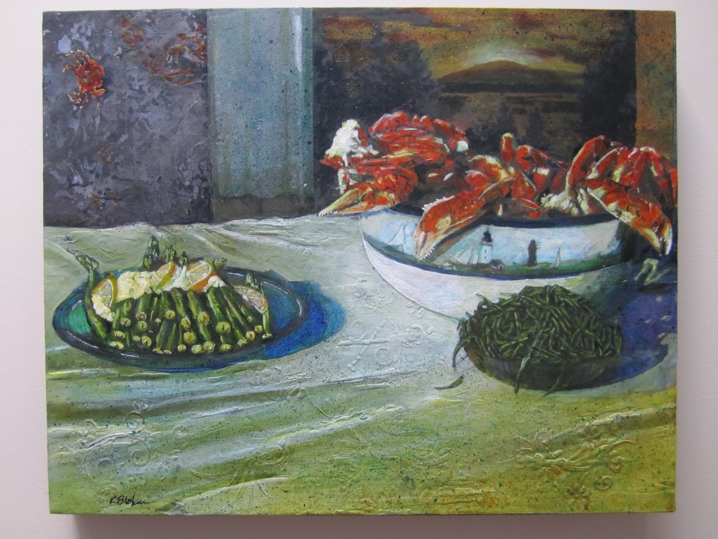 Still life of a bowl heaped with cooked crab, a plate of asparagus with lemon and a bowl of sea asparagus on a pale green cloth, a harbour sunset in the window behind